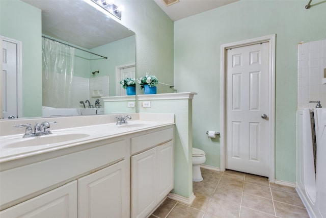 bathroom with curtained shower, tile patterned flooring, a sink, and toilet