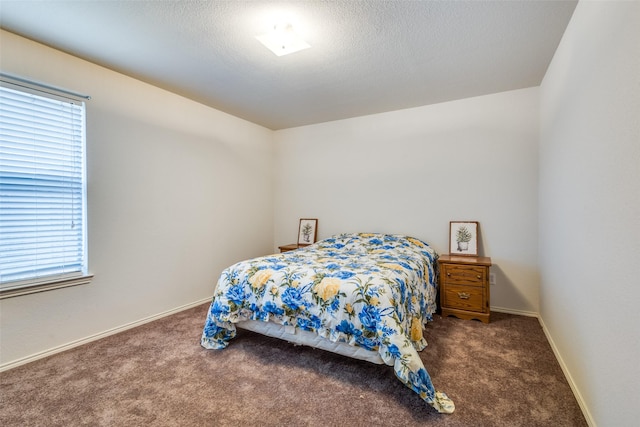 carpeted bedroom with a textured ceiling and baseboards