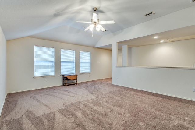 unfurnished room featuring attic access, visible vents, baseboards, vaulted ceiling, and carpet floors