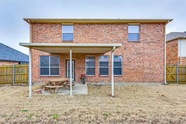 back of property featuring brick siding, a patio area, and fence