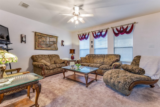 carpeted living area with ceiling fan and visible vents