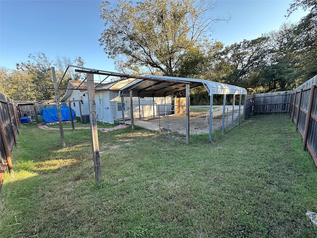 view of yard featuring a fenced backyard, central AC unit, and a carport