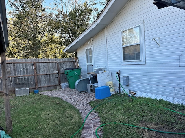 view of home's exterior with fence and a lawn