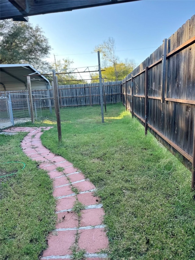 view of yard with a carport and a fenced backyard