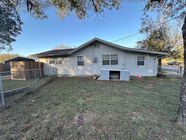 back of house featuring a yard and a fenced backyard