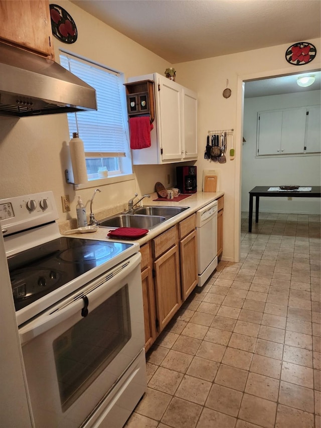 kitchen featuring white appliances, white cabinets, light countertops, under cabinet range hood, and a sink