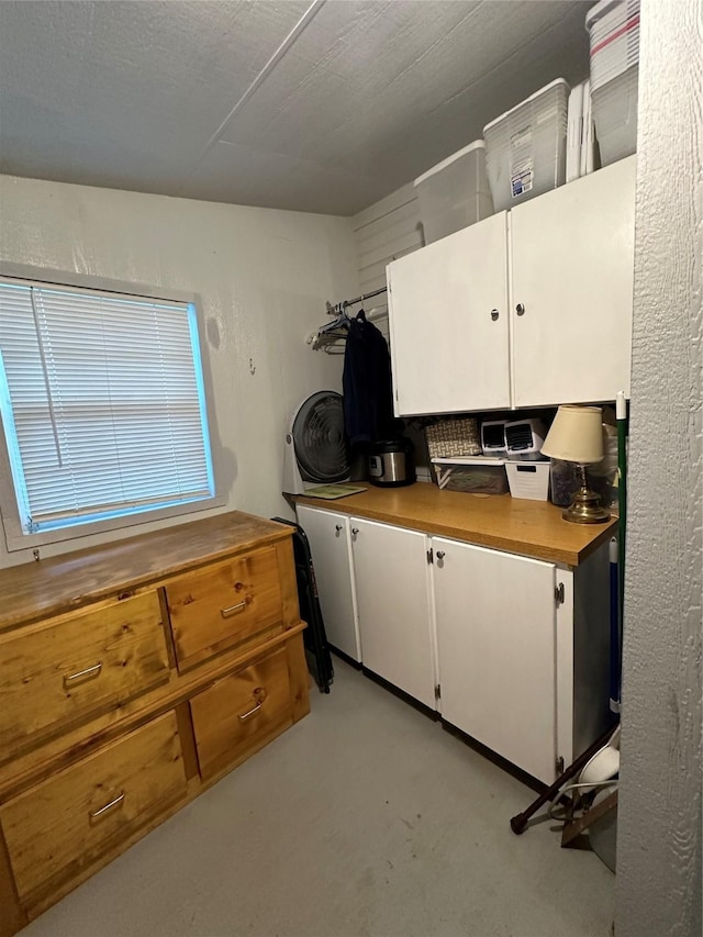 kitchen featuring concrete floors and white cabinets