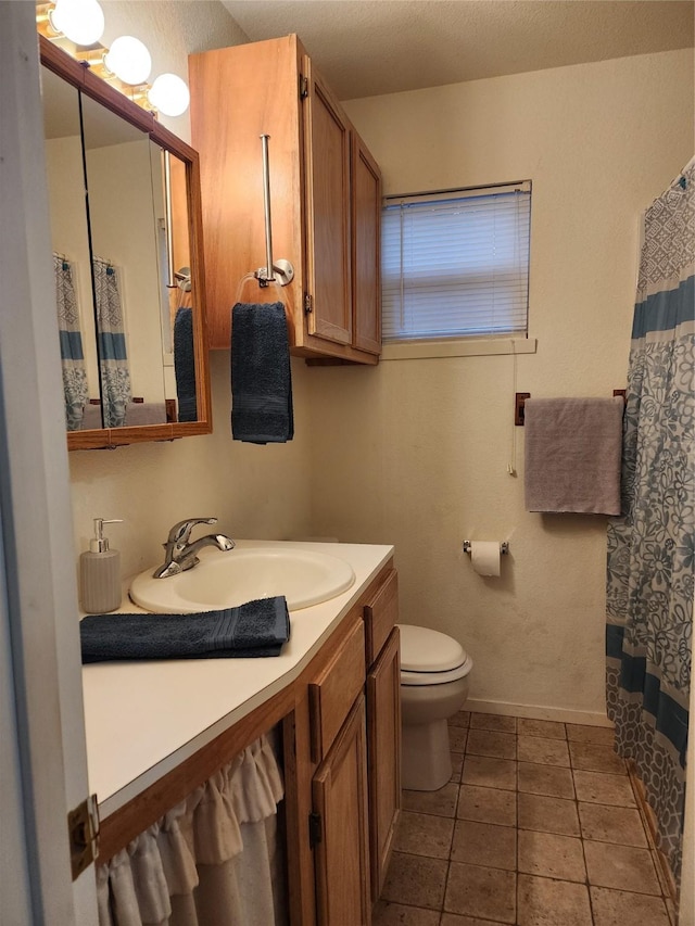 full bathroom with tile patterned flooring, baseboards, vanity, and toilet