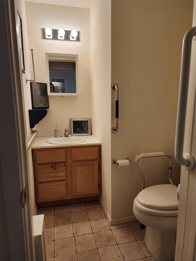 half bathroom with toilet, vanity, baseboards, and tile patterned floors