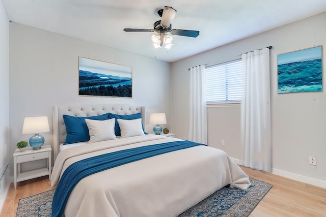 bedroom featuring light wood-style flooring, baseboards, and a ceiling fan