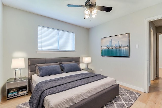 bedroom featuring baseboards, ceiling fan, and light wood-style floors