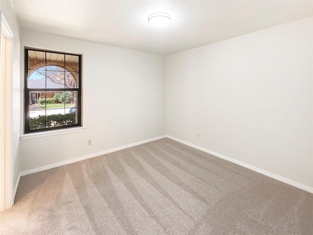 carpeted empty room with baseboards