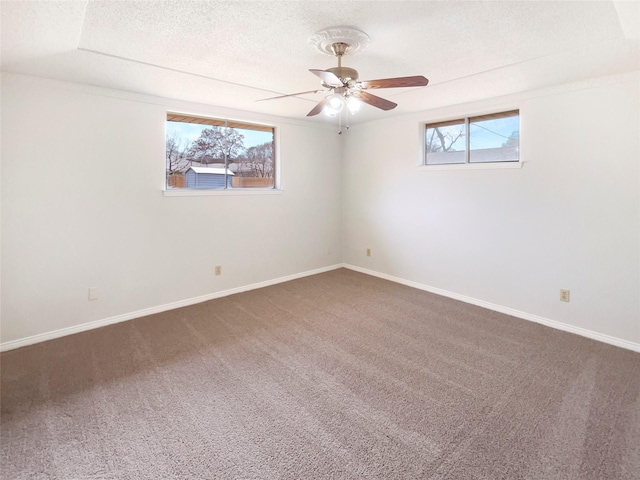 unfurnished room with carpet floors, a textured ceiling, baseboards, and a ceiling fan