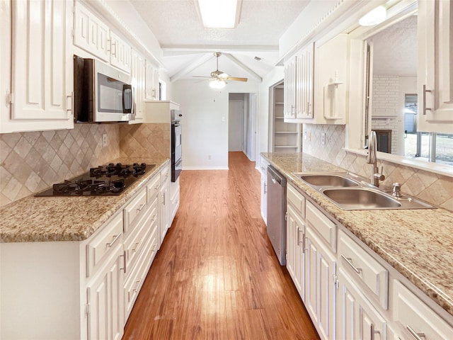 kitchen with lofted ceiling, ceiling fan, light wood-type flooring, black appliances, and a sink