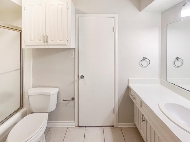 bathroom with toilet, vanity, and tile patterned floors