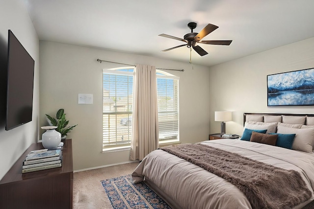 carpeted bedroom with ceiling fan and baseboards