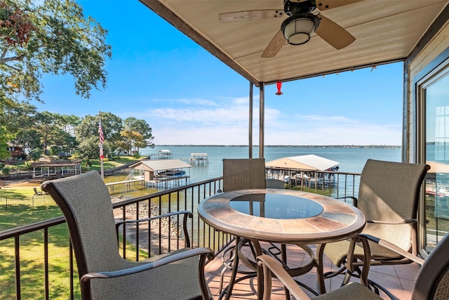 balcony with a ceiling fan, a sunroom, and a water view