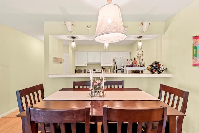 dining space with light wood-style floors and baseboards