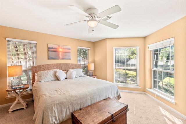 carpeted bedroom with ceiling fan and baseboards