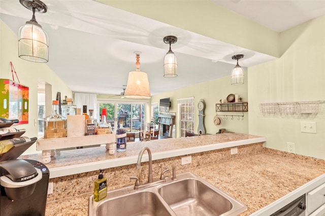 kitchen with open floor plan, hanging light fixtures, and a sink
