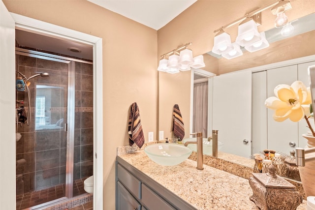 bathroom featuring vanity, toilet, and a stall shower