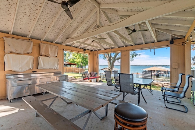 view of patio / terrace with a ceiling fan, a water view, fence, a gazebo, and outdoor dining space