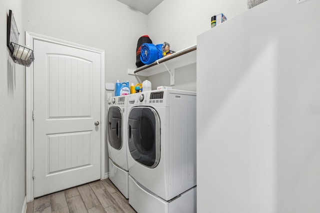 washroom featuring light wood-style floors, laundry area, and separate washer and dryer