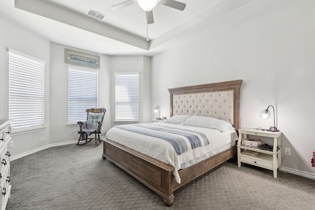 bedroom featuring carpet floors, a raised ceiling, visible vents, and baseboards