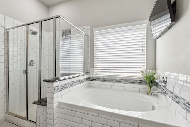 bathroom featuring a shower stall and a bath