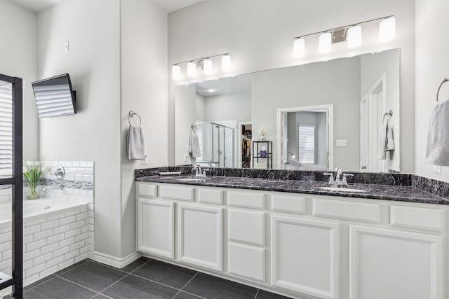 bathroom with a sink, a bath, tile patterned floors, double vanity, and a stall shower