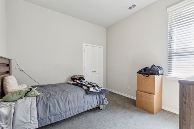 carpeted bedroom featuring baseboards, visible vents, and a closet