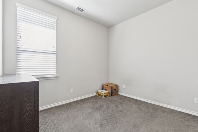 carpeted empty room with visible vents and baseboards