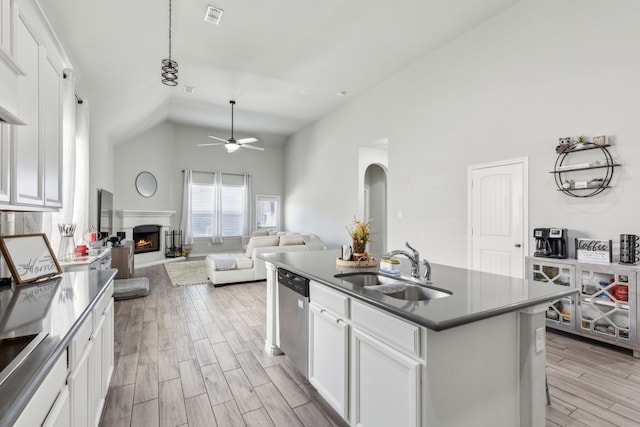 kitchen featuring dishwasher, a lit fireplace, a sink, and wood tiled floor