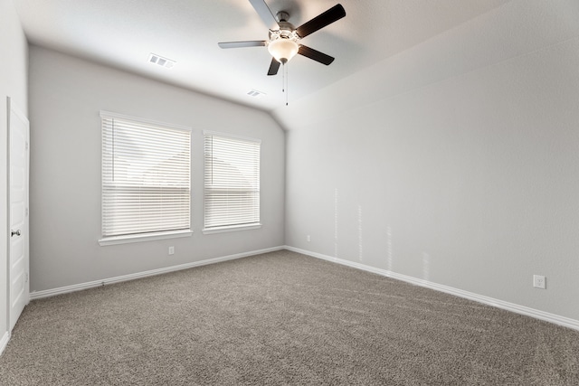 empty room with carpet floors, baseboards, and vaulted ceiling