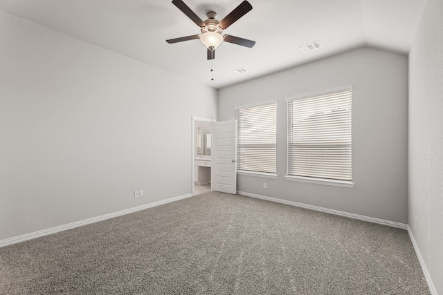 unfurnished bedroom with carpet flooring, vaulted ceiling, visible vents, and baseboards