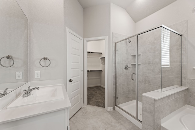 bathroom featuring a stall shower, a tub, tile patterned flooring, a spacious closet, and vanity