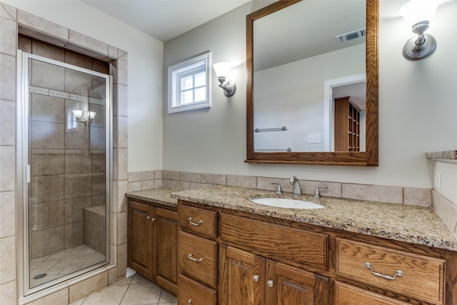 bathroom with visible vents, vanity, a shower stall, and tile patterned flooring