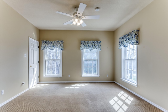 spare room with ceiling fan, baseboards, and carpet