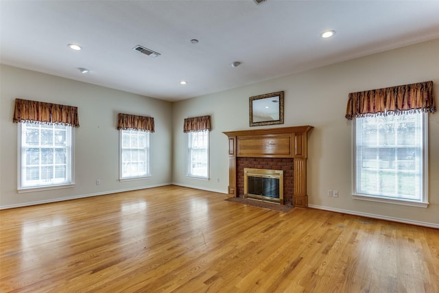 unfurnished living room featuring light wood finished floors, visible vents, baseboards, recessed lighting, and a fireplace