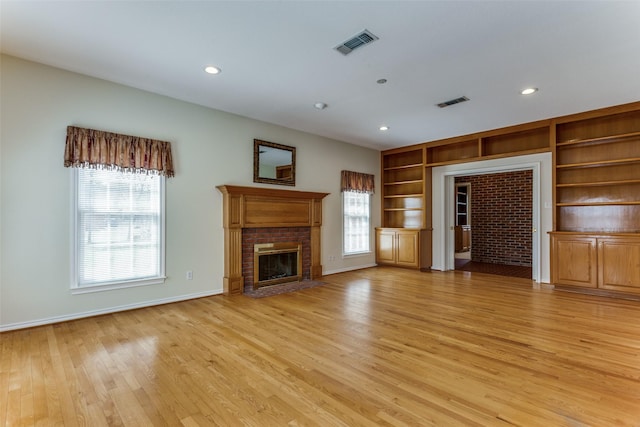 unfurnished living room featuring visible vents, a brick fireplace, baseboards, recessed lighting, and light wood-style flooring