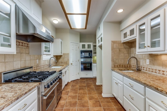 kitchen featuring a sink, light stone counters, black appliances, and exhaust hood