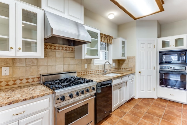 kitchen featuring a sink, light stone counters, custom exhaust hood, and black appliances