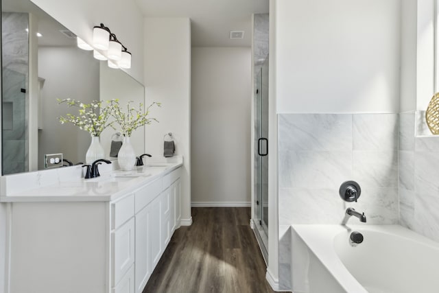 bathroom featuring wood finished floors, a stall shower, a sink, and a bath