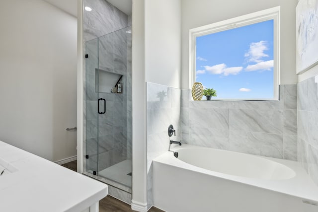 full bathroom featuring a stall shower and a bath