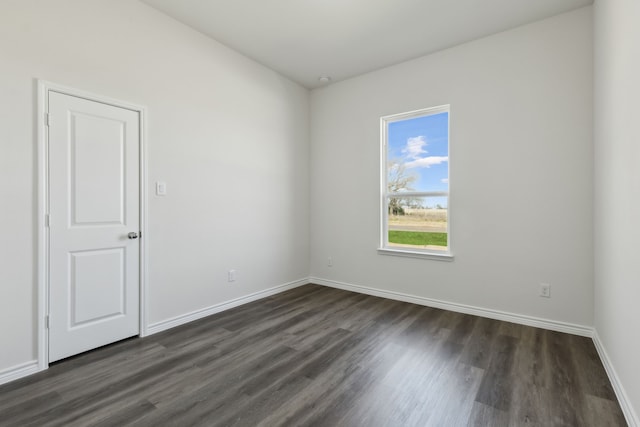 unfurnished room featuring dark wood-style flooring and baseboards