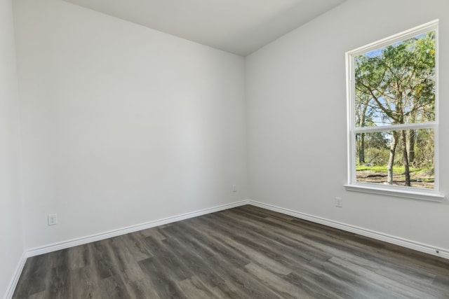 unfurnished room featuring dark wood-style floors and baseboards