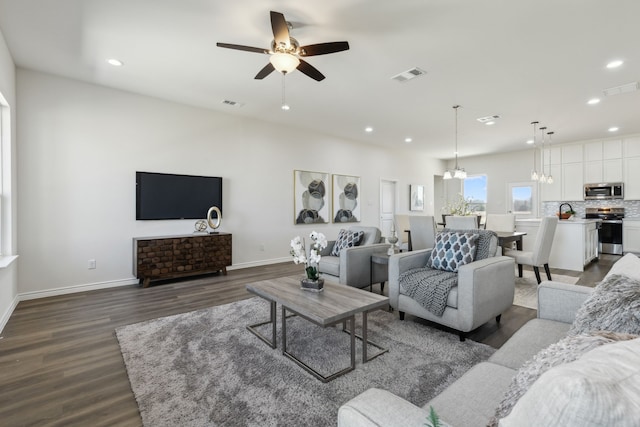 living area with baseboards, visible vents, dark wood-style flooring, and recessed lighting