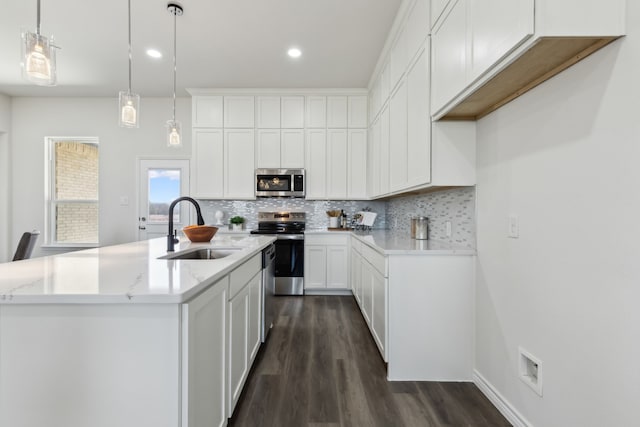 kitchen featuring stainless steel appliances, dark wood-type flooring, a sink, and decorative backsplash