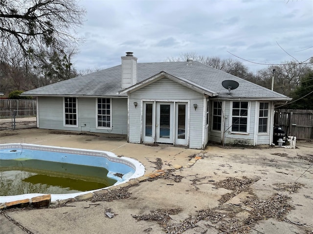 back of house with a chimney, fence, a fenced in pool, and a patio