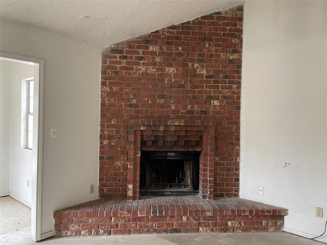 room details featuring a brick fireplace and a textured ceiling